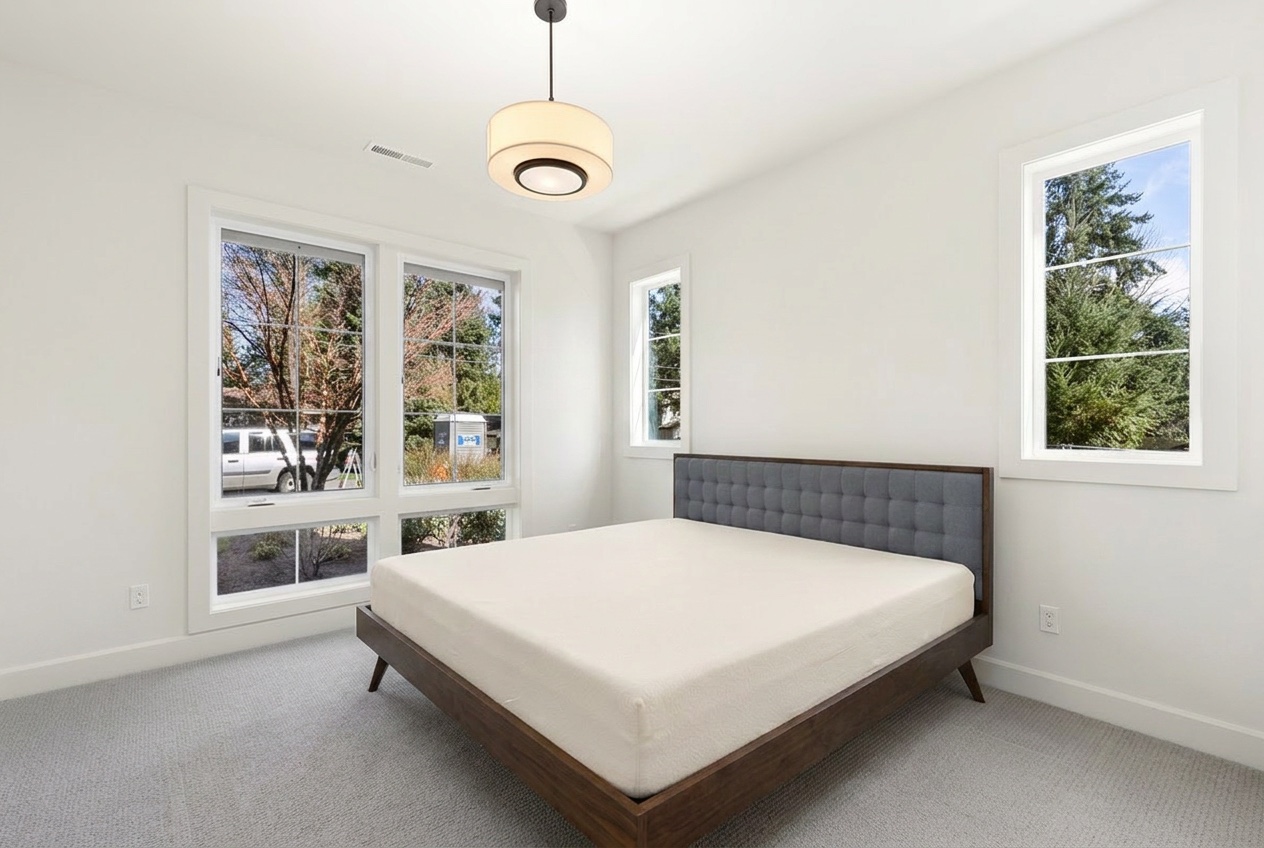 The bedroom with only the bed in it, before partial staging